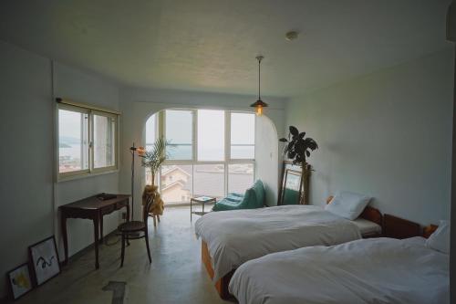 ein Hotelzimmer mit 2 Betten und einem Fenster in der Unterkunft Hotel 2YL Atami in Atami