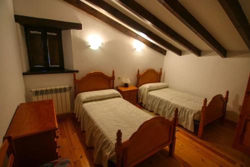 a room with two beds and a tv in it at Alojamiento Rural Casa La Mata. in Cuñaba