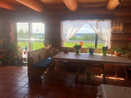 comedor con mesa y ventana en Cariboo Log Guest House, en Lac La Hache