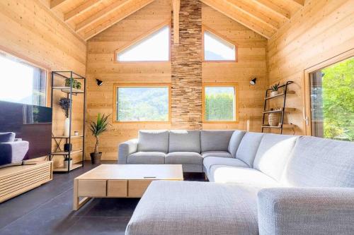 a living room with a couch and a table at ⁂ Chalet Alizée · Nature, lac et montagnes ⁂ in Alex