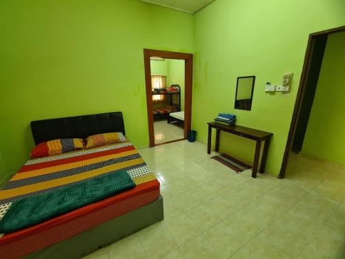 a bedroom with a bed and a table with a mirror at Penginapan Harmoni Inn in Kuala Terengganu