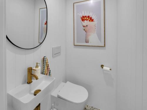 uma casa de banho com um lavatório branco e um espelho. em Gorgeous Getaway Toowoon Bay em Long Jetty