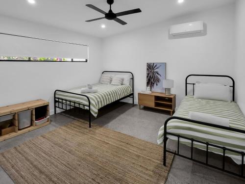 uma sala de estar com 2 camas e uma ventoinha em Gorgeous Getaway Toowoon Bay em Long Jetty