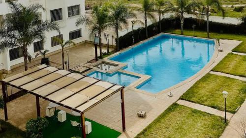 an overhead view of a swimming pool with palm trees at Nouaceur Garden in Casablanca