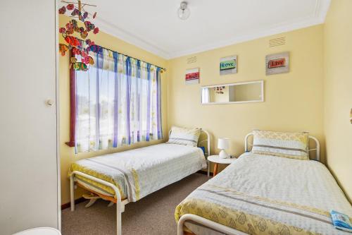 een slaapkamer met 2 bedden en een raam bij 27 Seashell Avenue Cape Woolamai VIC 3925 in Cape Woolamai