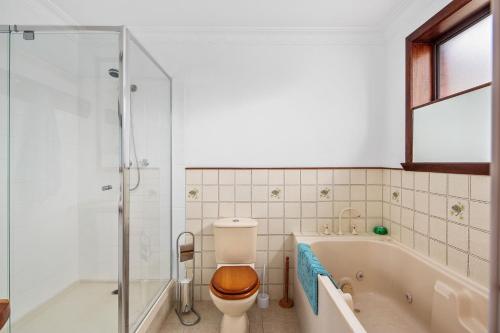 een badkamer met een bad, een toilet en een douche bij 27 Seashell Avenue Cape Woolamai VIC 3925 in Cape Woolamai
