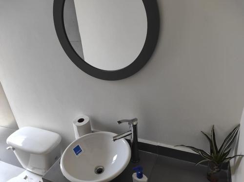 a bathroom with a white sink and a mirror at Corazón y color in Oaxaca City