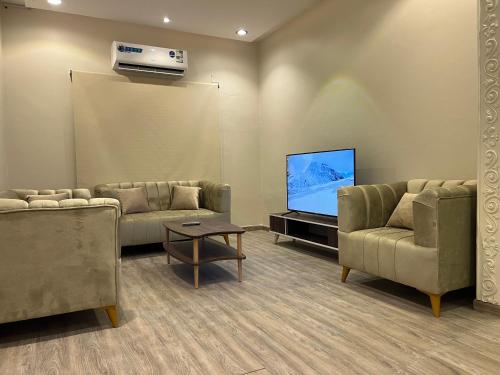 a living room with two couches and a flat screen tv at Hakimdom Hostel in Riyadh