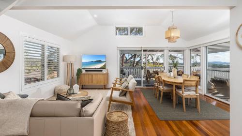 a living room with a couch and a table at Cabane Sur Mer in Shoal Bay