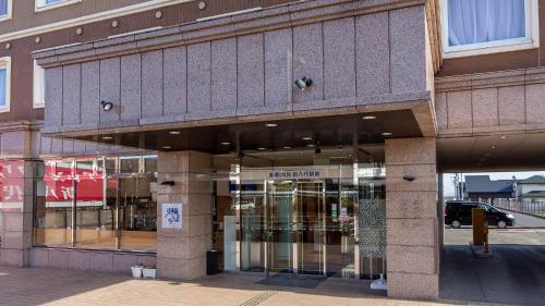 a store front with glass doors on a building at Toyoko Inn Shin-yatsushiro Ekimae in Yatsushiro