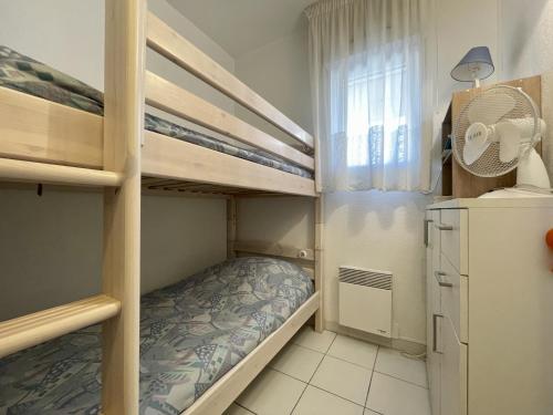 une petite chambre avec des lits superposés et un ventilateur dans l'établissement Appartement 4 pers, piscine, parking, climatisation en bord de mer - FR-1-338-508, à Sète