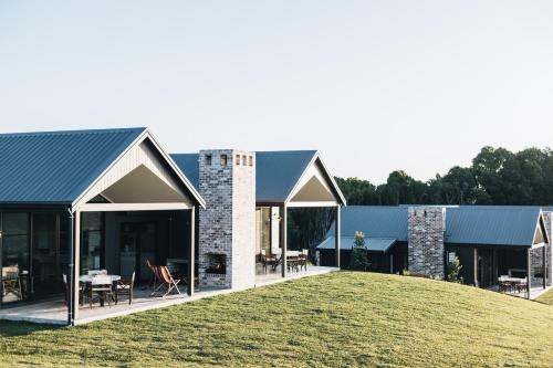 a house with a blue roof and a yard at The Brooklet in Brooklet