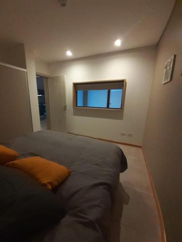 1 dormitorio con cama y ventana en Aire de Chapelco en San Martín de los Andes