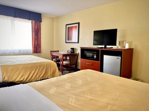 a hotel room with two beds and a flat screen tv at Quality Inn & Suites Wisconsin Dells Downtown - Waterparks Area in Wisconsin Dells