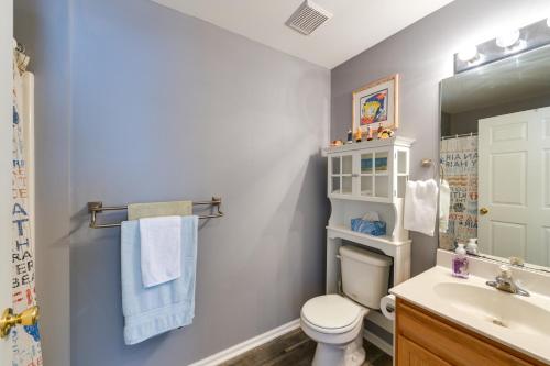 a bathroom with a toilet and a sink and a mirror at Condo with Deck Walk to Beach and Convention Center! in Wildwood