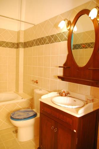 a bathroom with a sink and a toilet and a mirror at Spitaki in Plakias