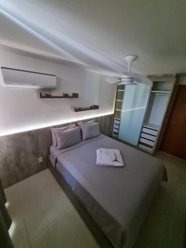 a bedroom with a bed with a white towel on it at Arraial do Cabo, Vista mar, conforto, Piscina. in Arraial do Cabo