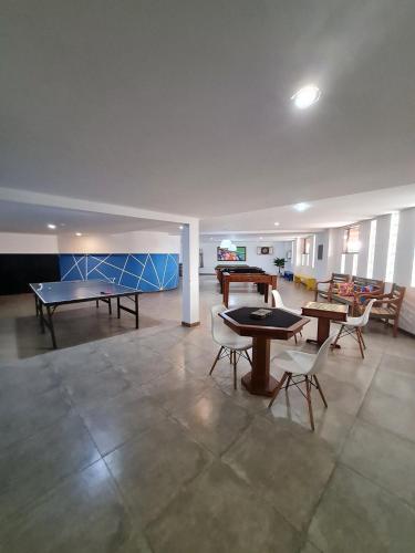a room with a ping pong table and chairs at Arraial do Cabo, Vista mar, conforto, Piscina. in Arraial do Cabo