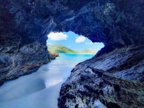 a cave in the rocks next to a body of water at Arraial do Cabo, Vista mar, conforto, Piscina. in Arraial do Cabo