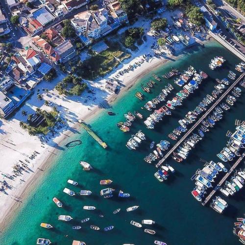 an aerial view of a marina with boats in the water at Arraial do Cabo, Vista mar, conforto, Piscina. in Arraial do Cabo