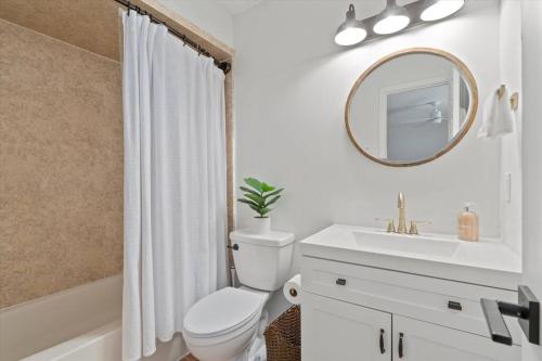 ein Badezimmer mit einem WC, einem Waschbecken und einem Spiegel in der Unterkunft Spacious Home Near Beach, Large Yard, Game Room and Dog Friendly in Jacksonville