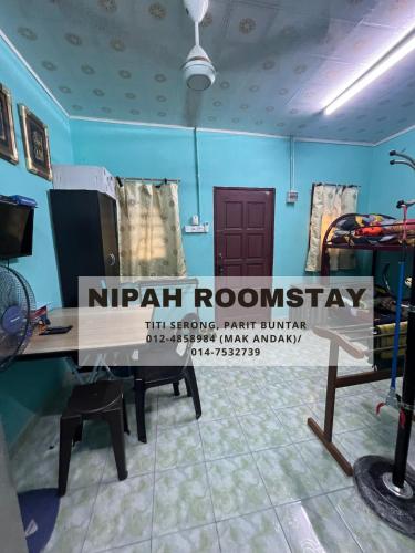 Cette chambre est dotée d'une table en bois avec un panneau. dans l'établissement NIPAH ROOMSTAY PARIT BUNTAR, à Parit Buntar