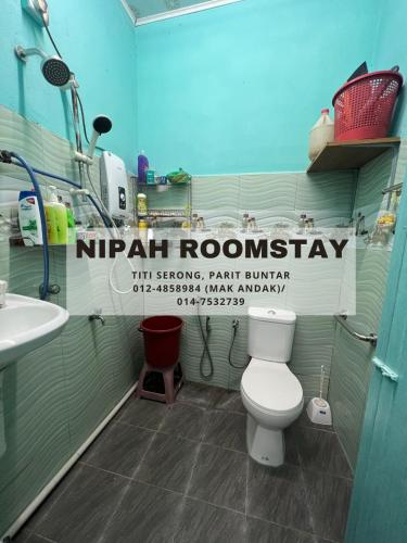 La salle de bains est pourvue de toilettes blanches et d'un lavabo. dans l'établissement NIPAH ROOMSTAY PARIT BUNTAR, à Parit Buntar