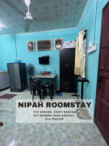 een kamer met een tafel en een bord dat nirvana kamerstay leest bij NIPAH ROOMSTAY PARIT BUNTAR in Parit Buntar