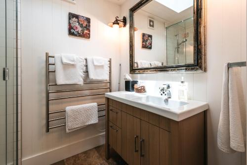a bathroom with a sink and a mirror at The Winemaker's Cottage - Coast & Country in Omiha