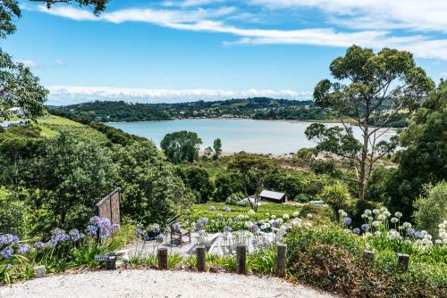 a garden with a view of a lake at The Winemaker's Cottage - Coast & Country in Omiha