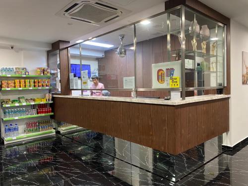 a person standing behind a counter in a store at The Concept Hotel KL - Batu Caves in Batu Caves