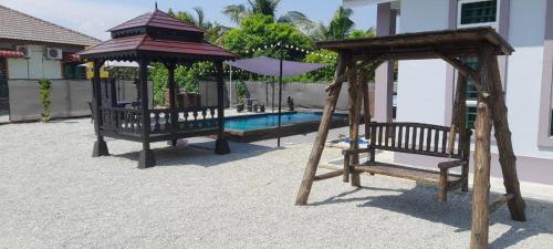 a playground with a gazebo and a pool at Homestay Restu Mak Abah Private Pool Melaka in Merlimau