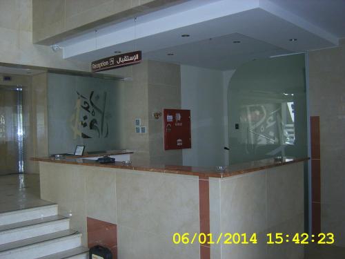 a lobby with a counter and stairs in a building at Athman Hotel in Makkah