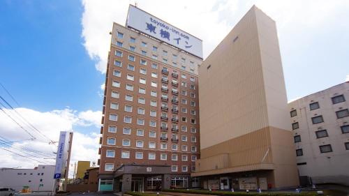 a tall building with a sign on top of it at Toyoko Inn Yonago Ekimae in Yonago