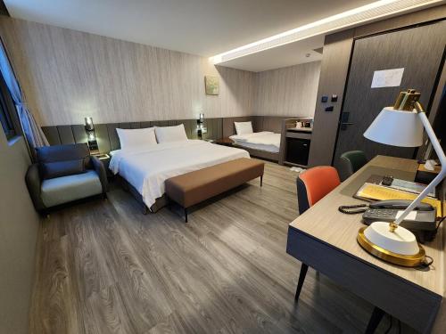 a hotel room with a bed and a desk at Hualien Pink Corner Hotel in Hualien City