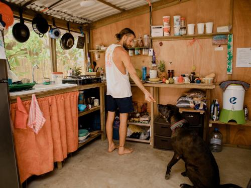a man standing in a kitchen with a dog at Casa Austera in El Paredón Buena Vista