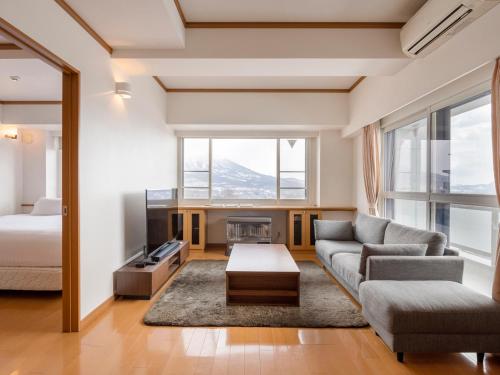 a living room with a couch and a bed at Mountainside Palace in Niseko