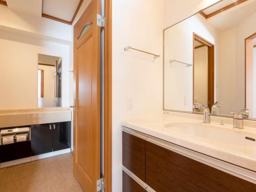 baño con lavabo y espejo grande en Mountainside Palace, en Niseko
