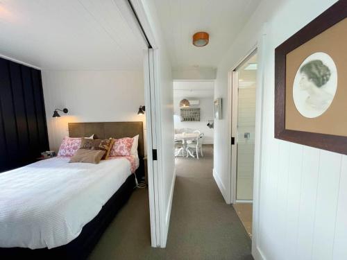a bedroom with a bed and a dining room at The Winemaker's Cottage - Coast & Country in Omiha