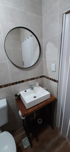een badkamer met een witte wastafel en een spiegel bij Casa Quinta Nuevo Torino -15 min de Rafaela 