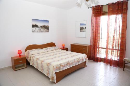 a bedroom with a bed and two night stands and windows at Villa Giù, indipendent villa near airport and sea in Cinisi