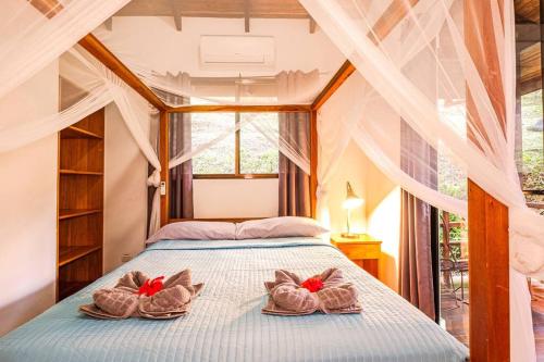 - une chambre avec un lit avec deux paires de chaussures dans l'établissement Villa Ángel (AC/Internet/Pool/Punta Uva beach), à Punta Uva