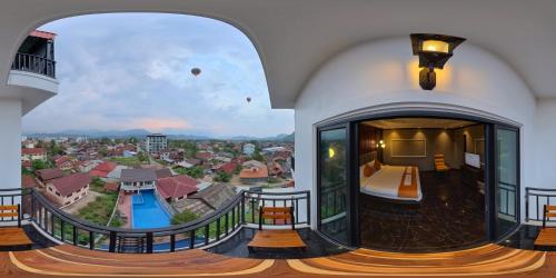 Camera con balcone affacciato su un resort. di Confetti Garden Hotel a Vang Vieng