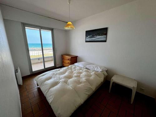 - une chambre avec un lit et une fenêtre donnant sur la plage dans l'établissement Quiberon - 2 pièces cosy à 20m de la plage avec parking - FR-1-478-247, à Quiberon