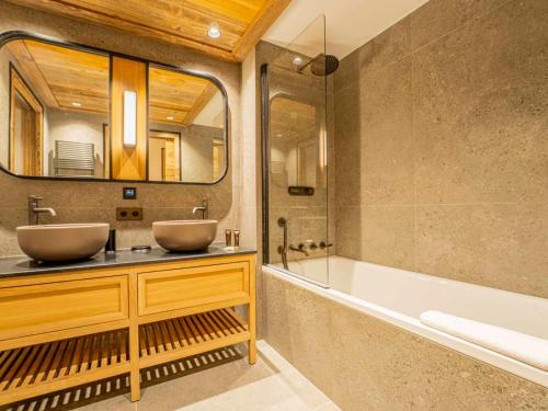 ein Badezimmer mit zwei Waschbecken und einer Badewanne und einem Spiegel in der Unterkunft Duplex Spacieux au Rond-Point des Pistes avec Parking, Balcon et Services Inclus - FR-1-613-93 in Les Allues