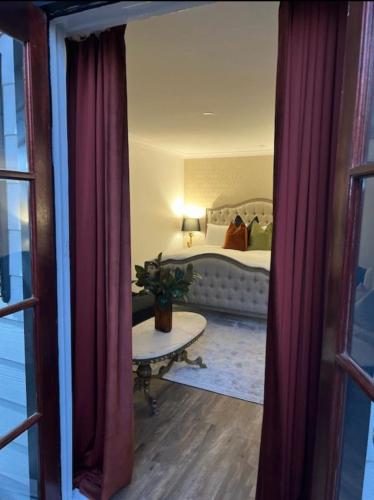 a bedroom with a bed and a table and curtains at Rústicoq B+B in Cowaramup