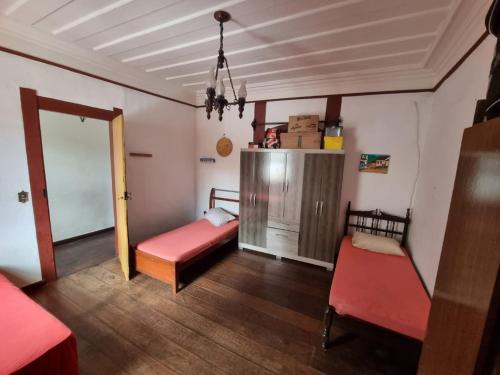 a room with two beds and a sliding door at República Estudantil Birinaite in Ouro Preto