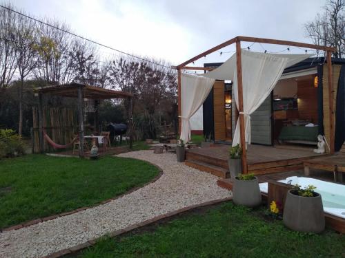 a backyard with a hot tub and a gazebo at Modo tiny relax spa in Duggan