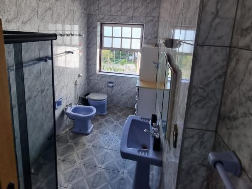 a bathroom with two toilets and a sink and a shower at República Birinaite in Ouro Preto