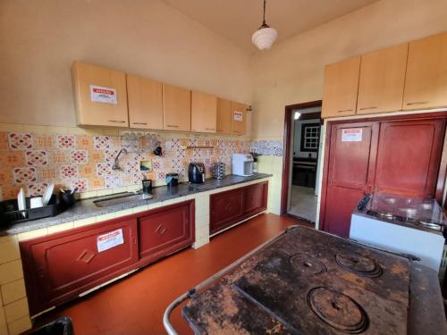 a kitchen with a red refrigerator and a stove top oven at República Birinaite in Ouro Preto